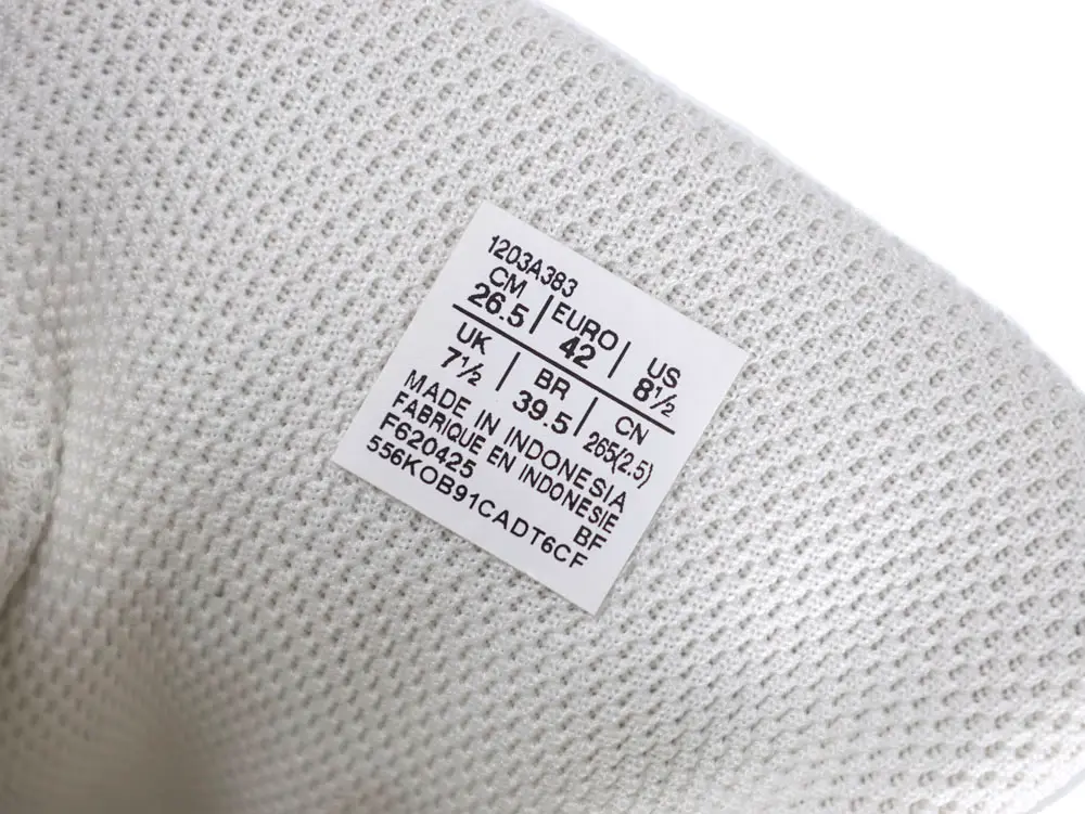 White textured fabric with a size label indicating manufacturing details and measurements.