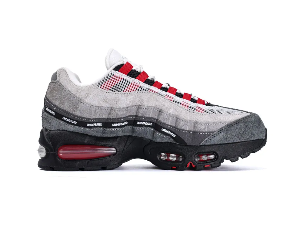 Gray and red sneaker with suede and mesh materials, featuring black sole.