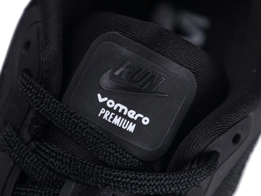 Black fabric and rubber athletic shoe with lace-up front and branded label detail.