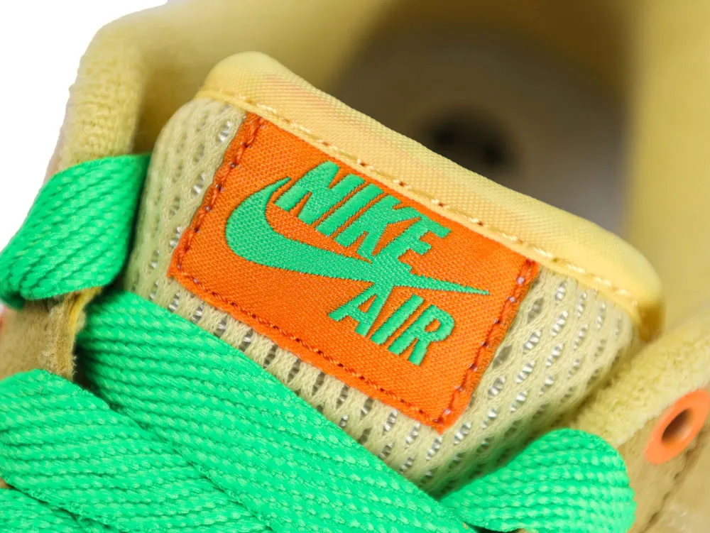 Yellow suede sneaker with vibrant green laces, orange label, and mesh tongue.