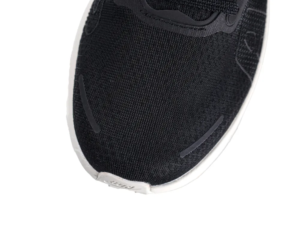Close-up of a black fabric sneaker's toe with a white rubber sole.