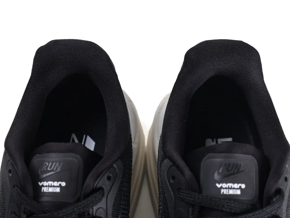 Close-up of black fabric sneaker tongues with embossed logos and black laces.