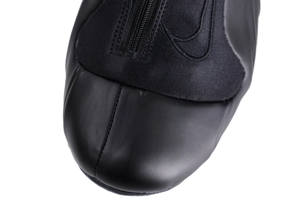Black leather shoe with fabric upper and zipper detail on top.