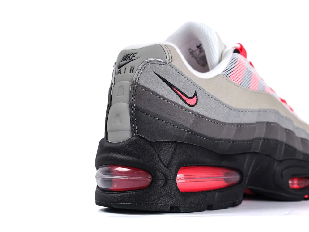 Gray and pink Nike shoe with black sole and red air cushioning.