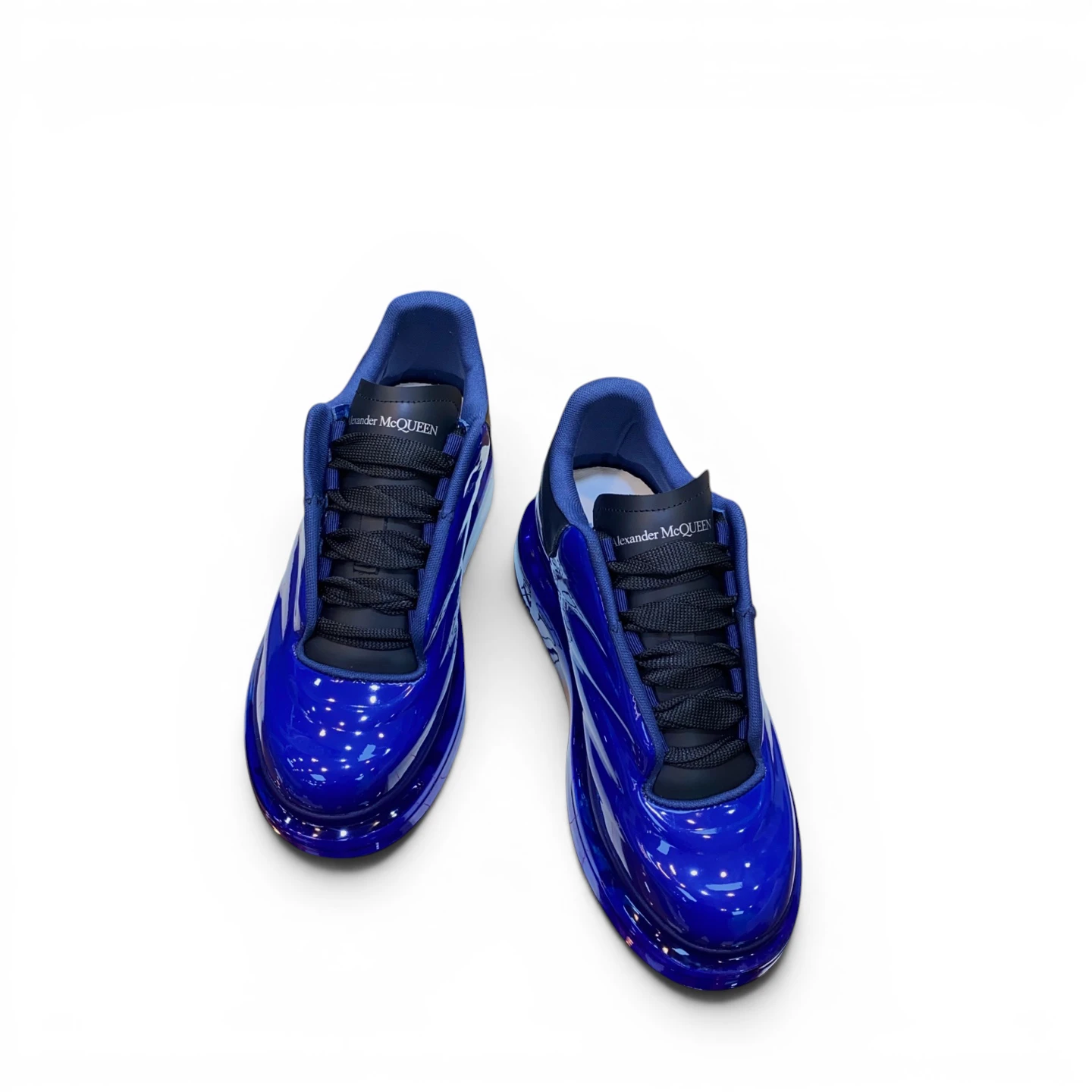 Blue patent leather sneakers with black laces, featuring brand logo on tongue.