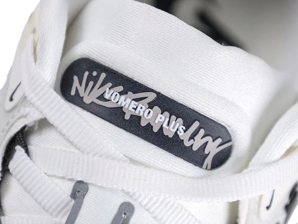 White fabric sneaker tongue with black and white logo tag.