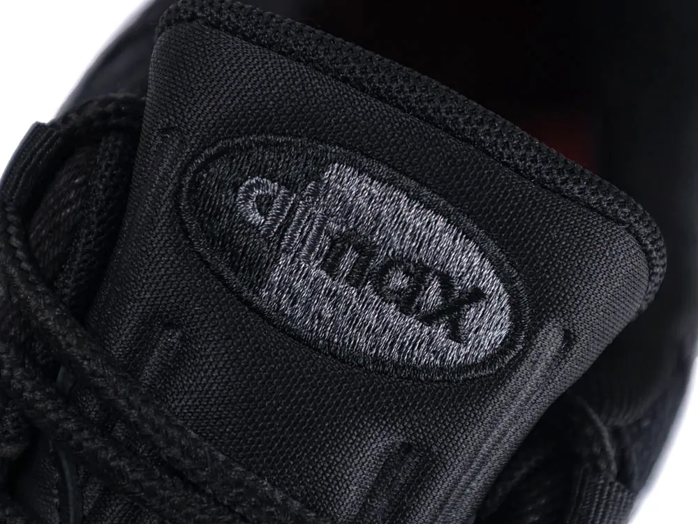 Close-up of black fabric shoe tongue with a stitched logo.