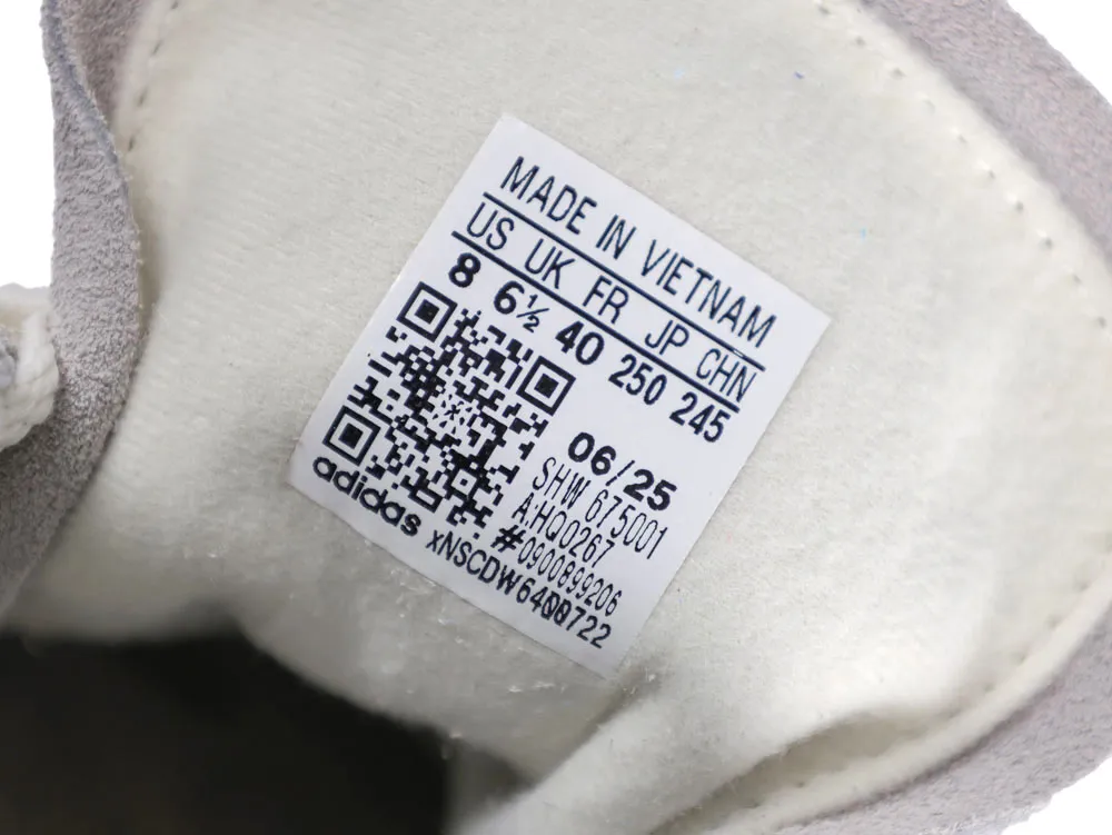 Gray suede and white fabric interior of a shoe with size label visible.