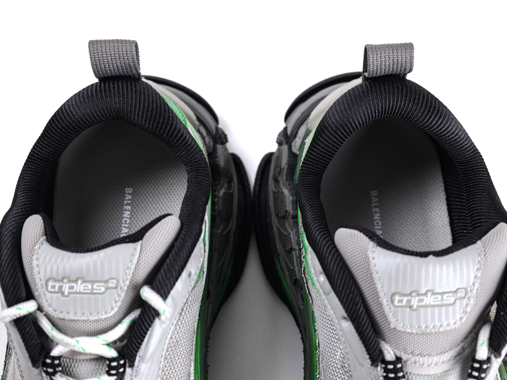 Gray and black sneakers with green accents, featuring mesh material and textured sole.