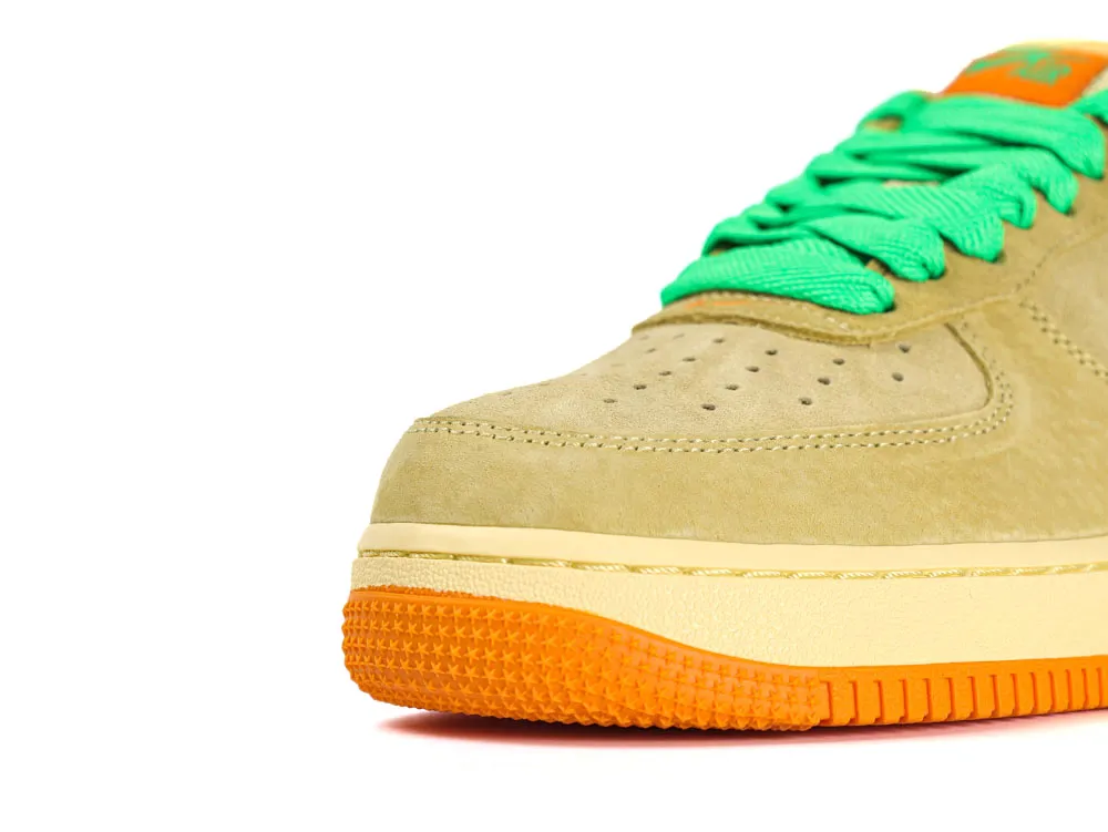 Beige suede sneaker with green laces and an orange textured rubber sole.