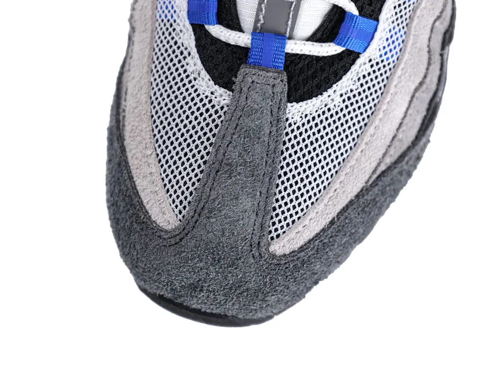 Close-up of a sneaker's gray suede and mesh upper with blue accents.