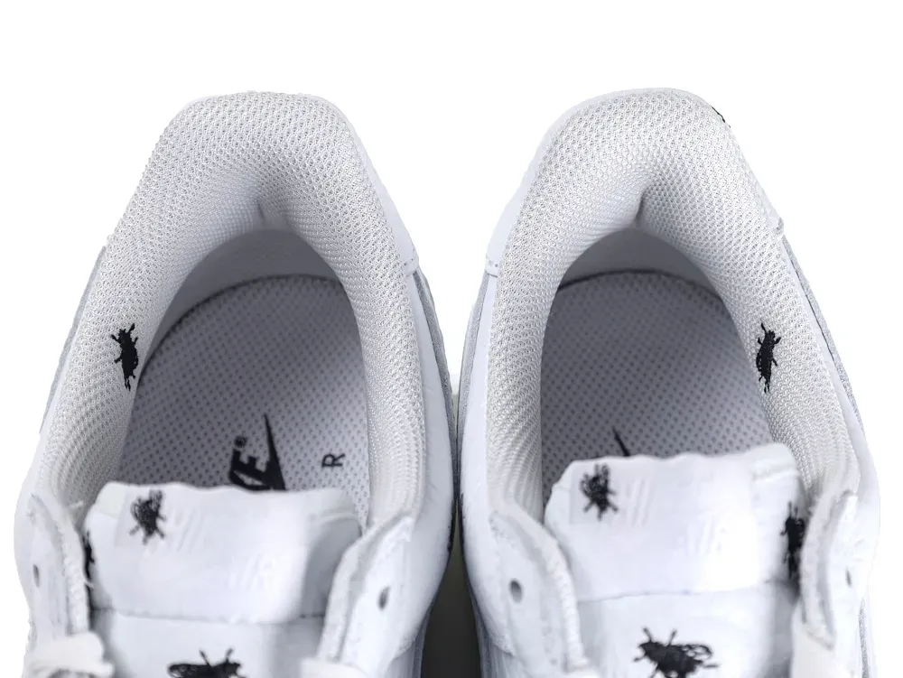 White fabric sneakers with black insect patterns on tongue and shoe interior.