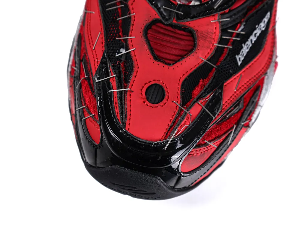 Red and black sneaker toe with leather accents and metal stitching details.