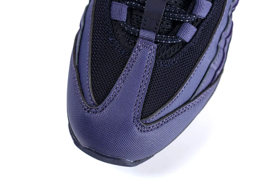 Close-up of a purple and black sneaker toe with mesh and textured material.
