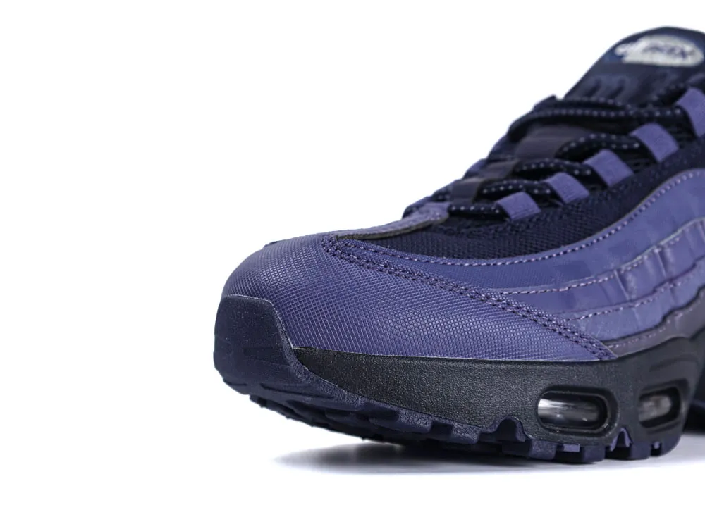 Close-up of a purple fabric sneaker's toe area with textured detailing.