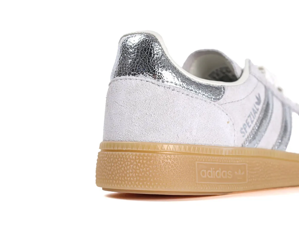 White suede sneaker with silver accents and a tan rubber sole.